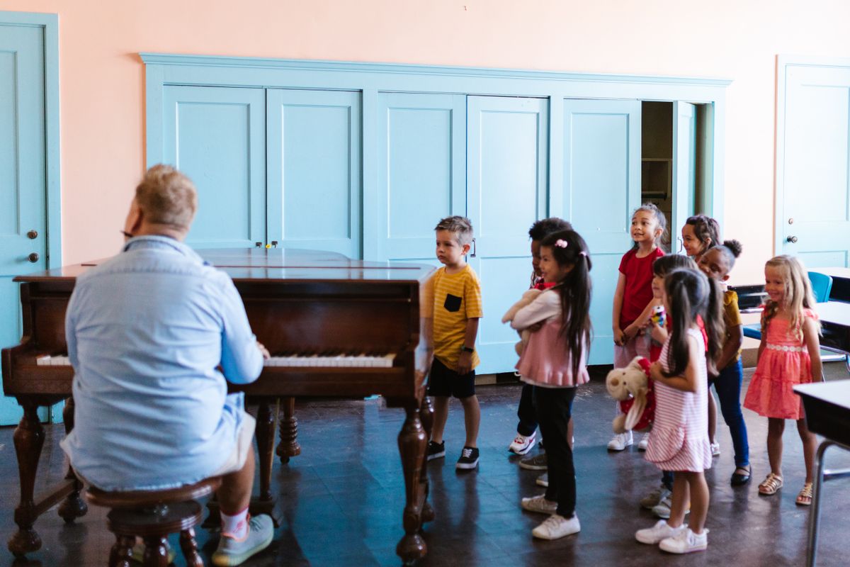Children learning to play the piano in a creative arts music studio